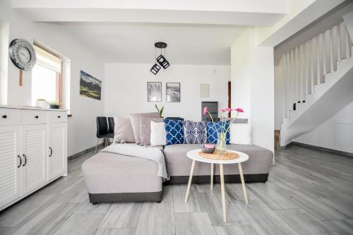 a living room with a couch and a table at Apartamenty Dwupoziomowe Na Dwa Widoki z Jacuzzi & Sauna in Zakopane