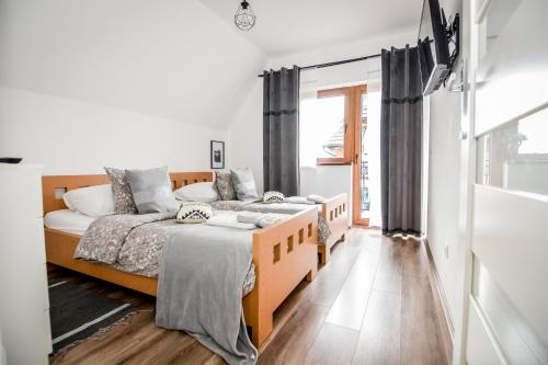a bedroom with two beds and a window at Apartamenty Dwupoziomowe Na Dwa Widoki z Jacuzzi & Sauna in Zakopane