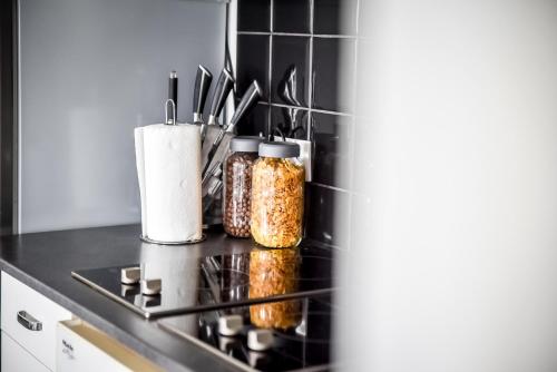 a kitchen counter with jars of food on a stove at Apartamenty Dwupoziomowe Na Dwa Widoki z Jacuzzi & Sauna in Zakopane