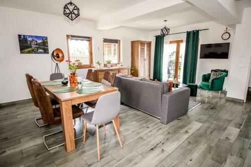 a living room with a table and a couch at Apartamenty Dwupoziomowe Na Dwa Widoki z Jacuzzi & Sauna in Zakopane