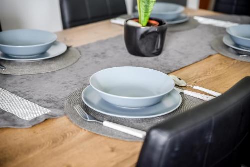 a table with bowls and plates on top of it at Apartamenty Dwupoziomowe Na Dwa Widoki z Jacuzzi & Sauna in Zakopane