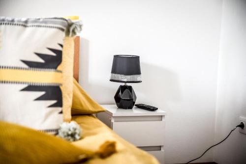 a bedroom with a bed and a lamp on a nightstand at Apartamenty Dwupoziomowe Na Dwa Widoki z Jacuzzi & Sauna in Zakopane