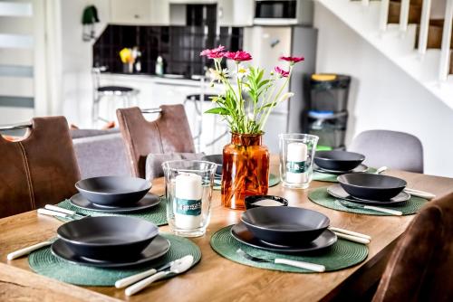 a wooden table with black bowls and plates on it at Apartamenty Dwupoziomowe Na Dwa Widoki z Jacuzzi & Sauna in Zakopane