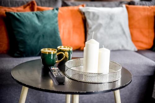a coffee table with candles and a remote control on a couch at Apartamenty Dwupoziomowe Na Dwa Widoki z Jacuzzi & Sauna in Zakopane