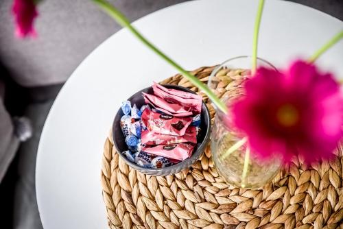 a basket with a pink flower and a vase with flowers at Apartamenty Dwupoziomowe Na Dwa Widoki z Jacuzzi & Sauna in Zakopane