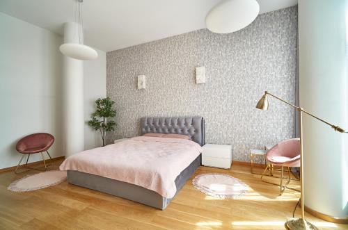 um quarto com uma cama e 2 cadeiras em Alexander apartment em Riga