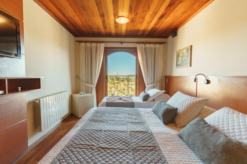 1 dormitorio con 2 camas y ventana en Pousada Recanto Almeida, en Campos do Jordão
