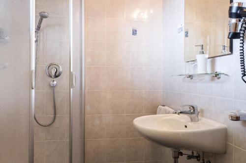 uma casa de banho com um lavatório e um chuveiro em Garni Schorneck em Brunico