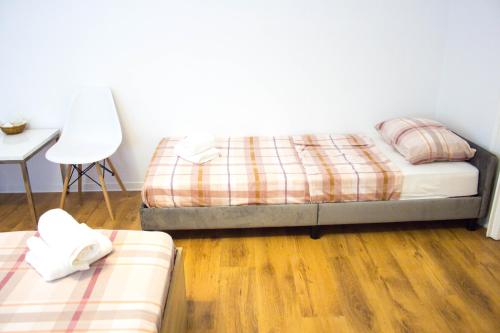 een slaapkamer met 2 bedden en een tafel en een stoel bij City Center Apartment Dina 2 in Rijeka