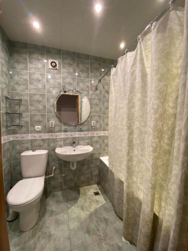 un bagno con un water, un lavandino e uno specchio di Rustaveli Ave Apartment a Batumi