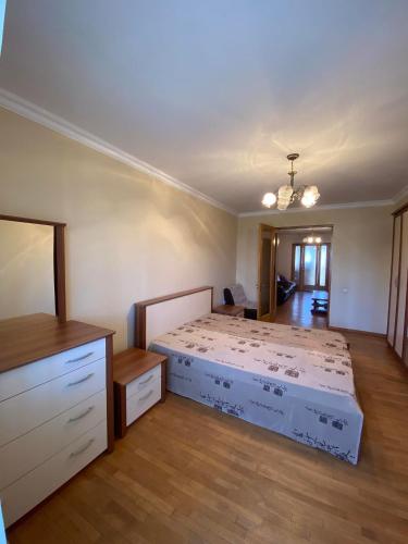 una camera da letto con un letto e una cassettiera di Rustaveli Ave Apartment a Batumi