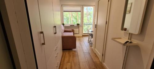 un corridoio con una stanza con una sedia e una finestra di Apartament 100 Blue Mare a Łukęcin