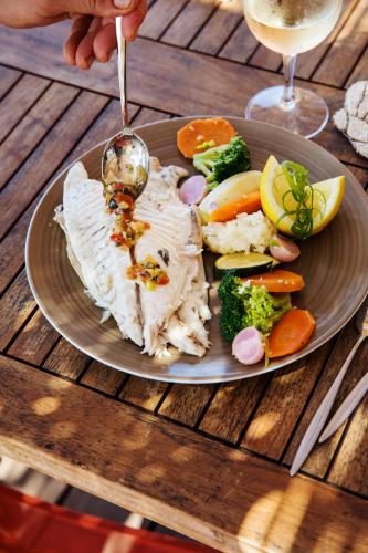 a plate of food with meat and vegetables on a table at Hôtel Le Bailli De Suffren in Rayol-Canadel-sur-Mer