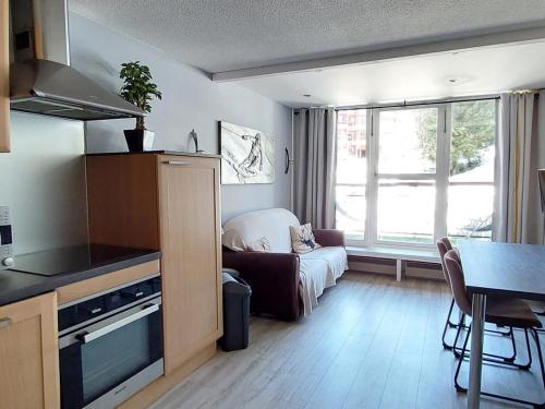 une cuisine et un salon avec un canapé et une table dans l'établissement Appartement 3 pièces en duplex, skis aux pieds, pour 6 personnes – Arc 1800 - FR-1-411-836, à Bourg-Saint-Maurice