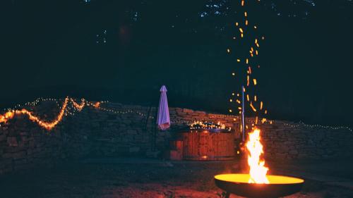 a fire pit in front of a wall at night at Chata Domaša - Nová Kelča in Valkov