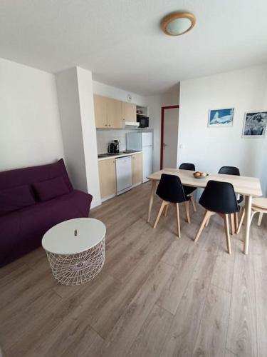 un salon avec un canapé, une table et des chaises dans l'établissement Appartement 1 chambre, résidence Les Chalets, à Puy-Saint-Vincent