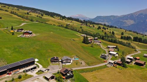 an aerial view of a house in a green field at Gasthaus Alpina in Tschappina
