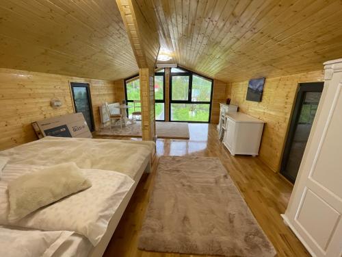 ein großes Schlafzimmer mit einem Bett in einem Holzhaus in der Unterkunft Pensiunea AlexOlar New One in Arada