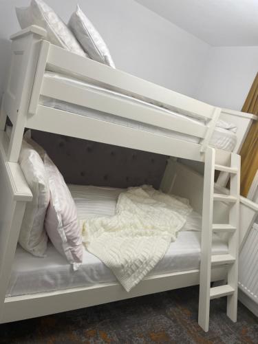 a white bunk bed with white sheets and pillows at Pensiunea AlexOlar New One in Horea