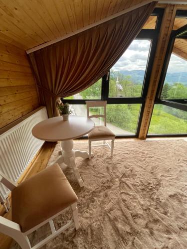 a room with a table and chairs and windows at Pensiunea AlexOlar New One in Horea