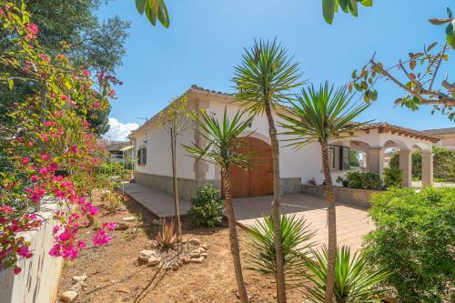 a house with palm trees in front of it at Casa Aina in Sa Ràpita
