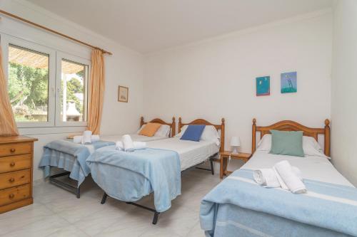 a bedroom with two beds and a window at Casa Aina in Sa Ràpita