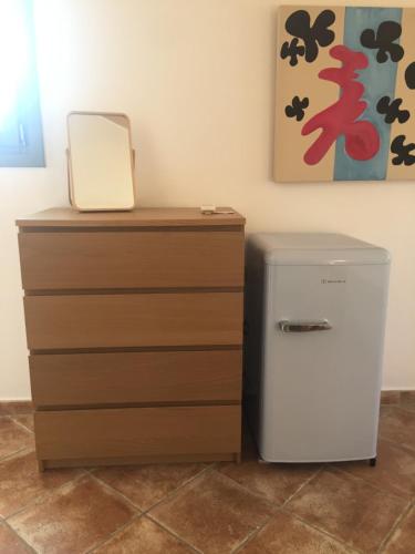 a small refrigerator next to a dresser with a mirror at The Cove Assos in Asos