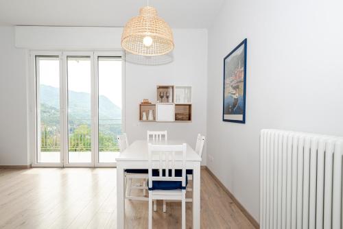 a white dining room with a white table and chairs at Mamo's Belvedere by Holiday Solutions in Faggeto Lario 