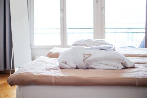 two beds with white towels on top of them at Tertianum Residenza Al Parco Appartements & Restaurant in Locarno