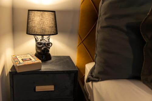 a bedside table with a lamp and a book at Flaka's Apartment in Vienna