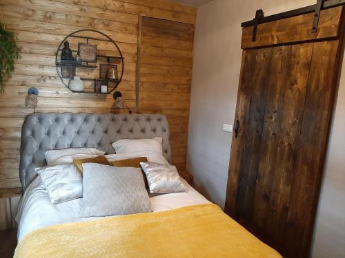 een slaapkamer met een bed en een houten muur bij Jacuzzi huisje De Berenshoeve in Emmen