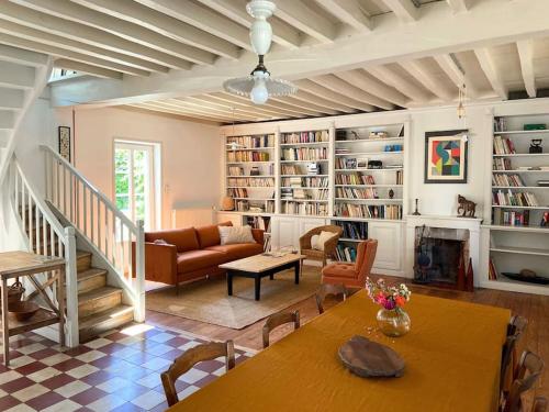 a living room with a table and a couch at Maison d'hôtes et gîte de charme avec piscine, La Lhuiseraie in Lhuis