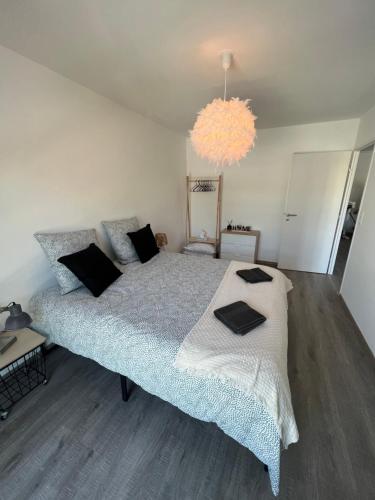 een slaapkamer met een groot bed en een kroonluchter bij Chez Olivia in Arras