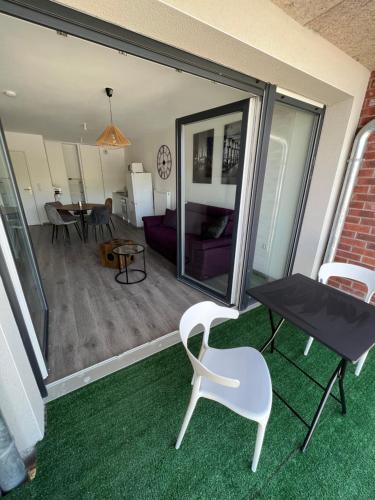 een balkon met een tafel en een stoel en een woonkamer bij Chez Olivia in Arras