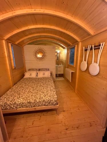 1 dormitorio en una casa pequeña con cama y utensilios de cocina en ROULOTTE NATIRAA, en Tarascon