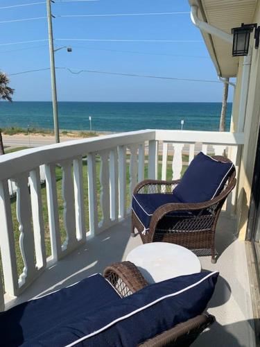 a balcony with a table and chairs and the ocean at Ormond Beach, fun & loving sun! in Ormond Beach
