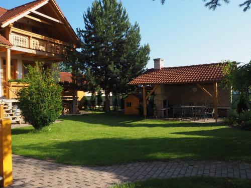 a house with a green yard with chairs and trees at Privat Alenka in Liptovský Mikuláš