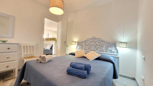 um quarto com uma cama azul com duas toalhas em Il Giardino davanti al Mare em Orosei