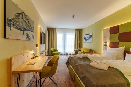 クアオルト・オーバーヴィーゼンタールにあるRathaushotels Oberwiesenthal All Inclusiveのベッドとデスクが備わるホテルルームです。