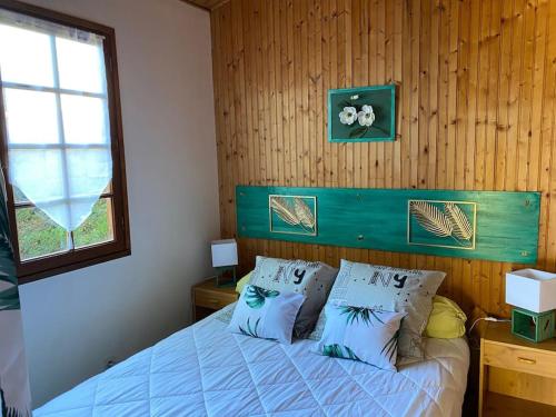 - une chambre avec un lit bleu avec des oreillers et une fenêtre dans l'établissement Maison de type chalet piscine collective hume, à Gujan-Mestras