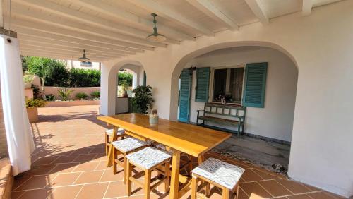 een houten tafel en stoelen op een patio bij Il Giardino davanti al Mare in Orosei