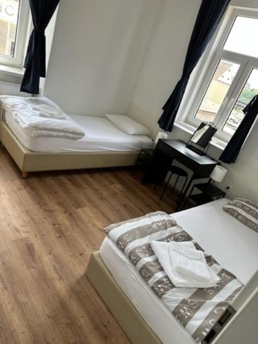 a room with two beds and a desk with a window at Gostilna in apartmaji Zlati lev - Maribor in Maribor