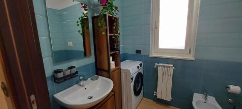 a bathroom with a sink and a washing machine at Casa vacanze Fantasia - Nuovo! Accogliente appartamento in Barletta