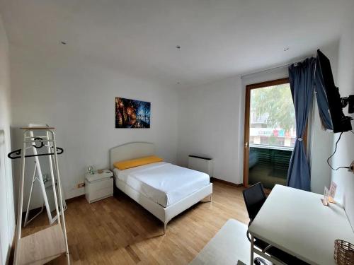 Schlafzimmer mit einem Bett, einem Schreibtisch und einem Fenster in der Unterkunft Kalimera in Bari