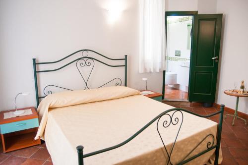 a bedroom with a bed and a green door at B&B Casa Andrea in Taormina
