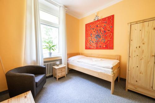 a bedroom with a bed and a chair and a window at Lázně Meziboří in Meziboři