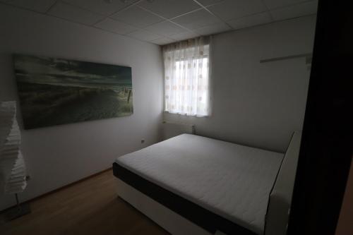 a bedroom with a white bed and a window at Ferienwohnung GGM in Judenburg