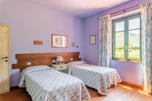 a bedroom with two beds and a window at Alba al Rifugio Arcobaleno in Popiglio