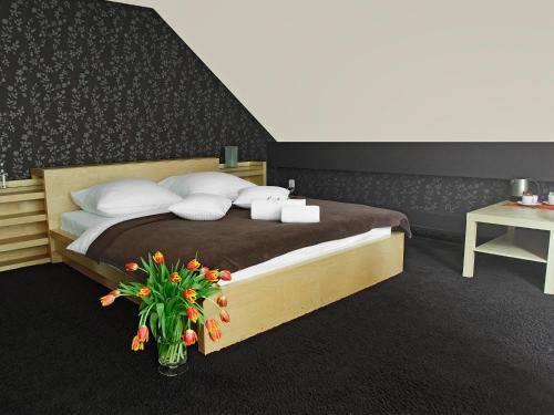a bedroom with a bed with a vase of flowers at An-Son Apartamenty in Zielona Góra
