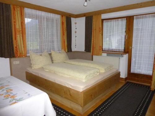a bedroom with a bed and two windows at Ferienwohnungen Hauser in Waidring